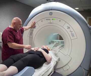 Technician getting a patient ready for a MRI scan.