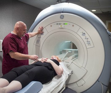 Technician getting a patient ready for a MRI scan.