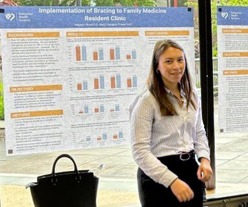 Woman and man standing in front of poster attached to windows.