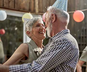 Happy senior couples dancing during a Birthday party on a terrace.