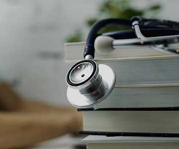 Stethoscope sitting on top of a pile of books