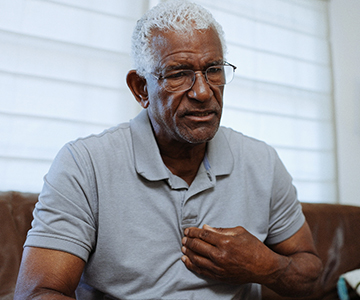 Senior man puts fingers on his chest