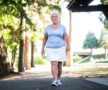 Laura Price, a neurosurgery patient, walks on a sidewalk