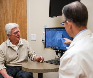 Joint Replacement patient Carl Anderson looking at x-rays with orthopedic surgeon Dr. James Ryan.