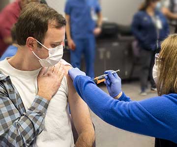 Dr. Adam Brady receives a covid-19 vaccine in 2021.