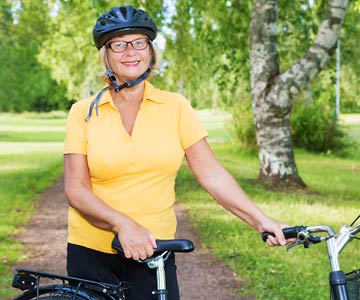 Woman standing next to bike wearing a helmet