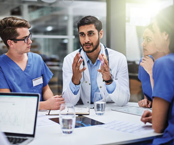 Doctors sitting around a table talking