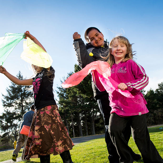 Smiling children playing with scarves.