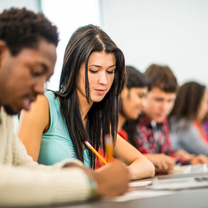 Students in class writing on paper.