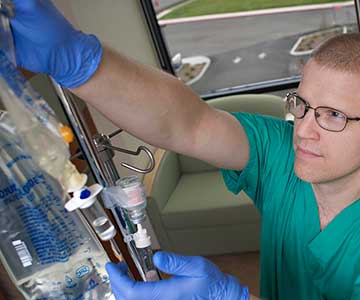 Male critical care nurse checking an IV bag