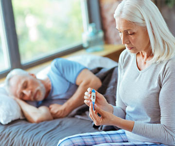 Woman taking a man's temperature.