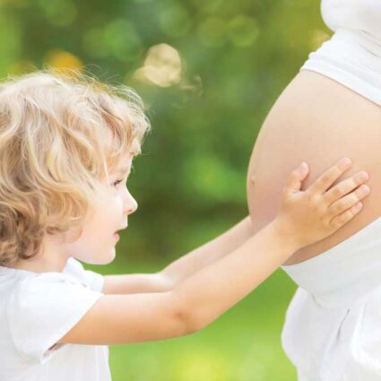 Child touching pregnant belly