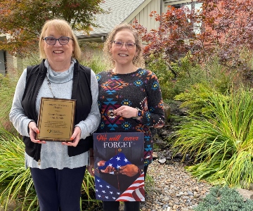 Diane Sanders and Sarah Smith standing with veterans hospice.