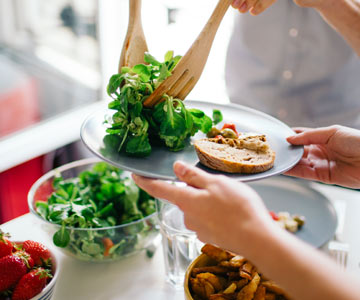 Serving salad on a plate of food.