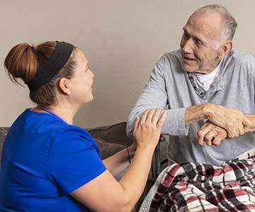 Caretaker speaking with an elderly man.