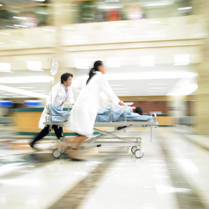 Two doctors rushing a patient on a gurney to surgery