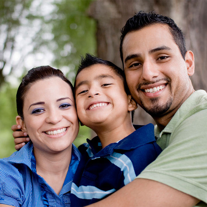 Mother, son and father hugging and smiling for camera.