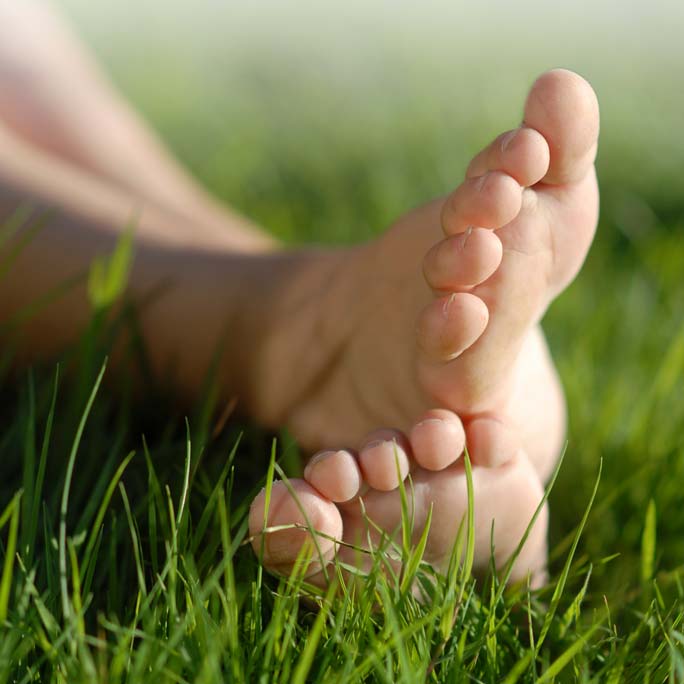 A close up of bare feet in grass.