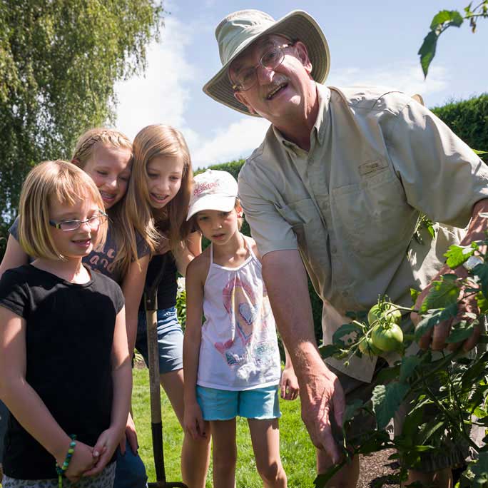 Heart patient in garden with grandchildren following Cardiac Rehabilitation program.