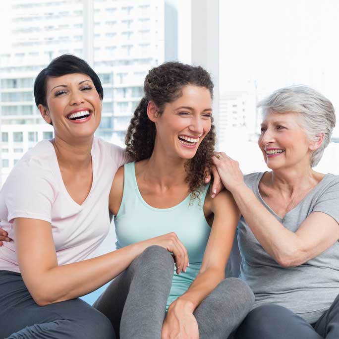 Three women hugging and smiling