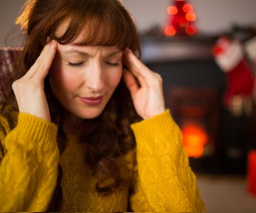 Woman holds her head with her hands