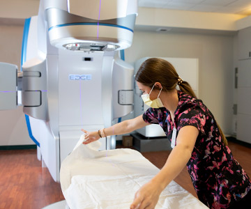 woman making bed in what looks like imaging room