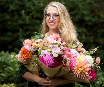 Nurse Practitioner Karen DuBois holding bouquets of flowers.