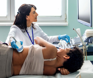 Patient laying down on their side while a clinician performs a kidney ultrasound.