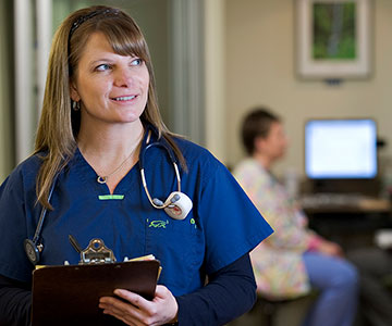 Graduate nurse program preceptor standing at nurses station