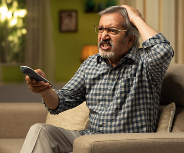 Man holding TV remote getting angry