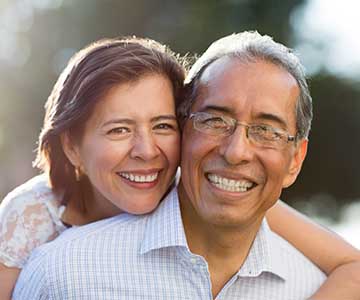 Mature or senior couple smiles at camera.