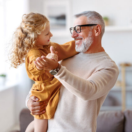 Senior man dancing with granddaughter