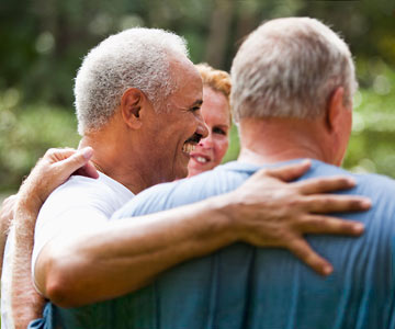 Group of men with arms around each other in support.