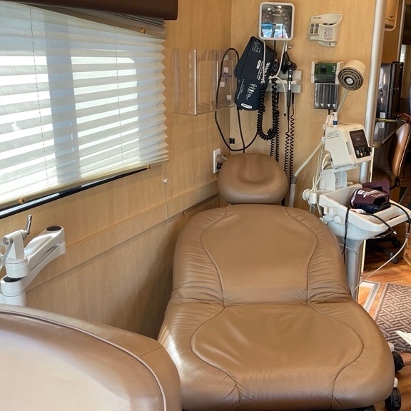 Brown reclining medical chair inside a ten bus