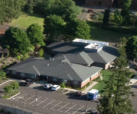 Aerial view of two roof lines and a parking lot at Mario Pastega House in Corvallis, Oregon.