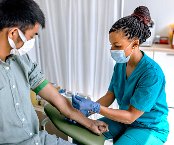 Phlebotomist working with a patient.