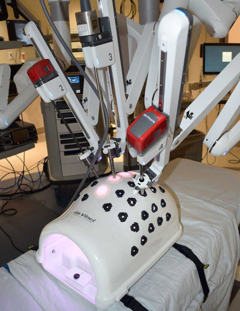 A close up of the da Vinci robot working on a "training torso."