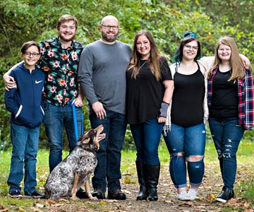Ashley with her whole family gathered outdoors together.