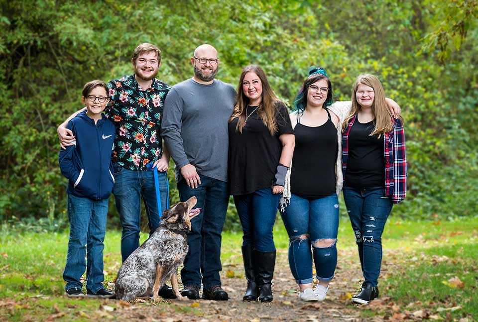 Ashley with her whole family gathered outdoors together.