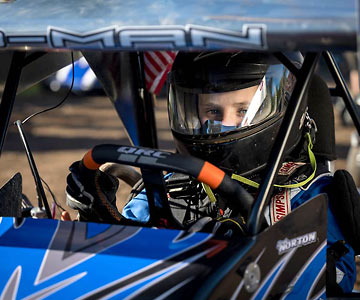 Close up of Brody with his helmet on as he sits in his race car.