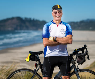Conrad, smiling, standing with his bike above Nye Beach in Newport, Oregon.