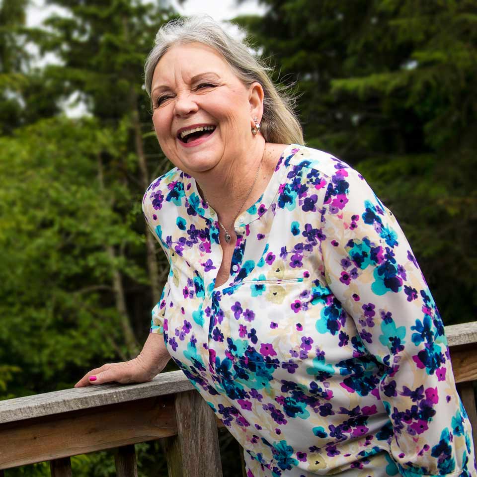Donni laughing merrily while standing outdoors.