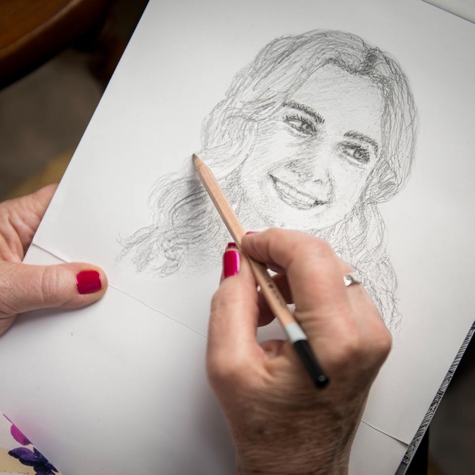 Close of Donni's hand as she sketches a drawing of her beloved granddaughter.