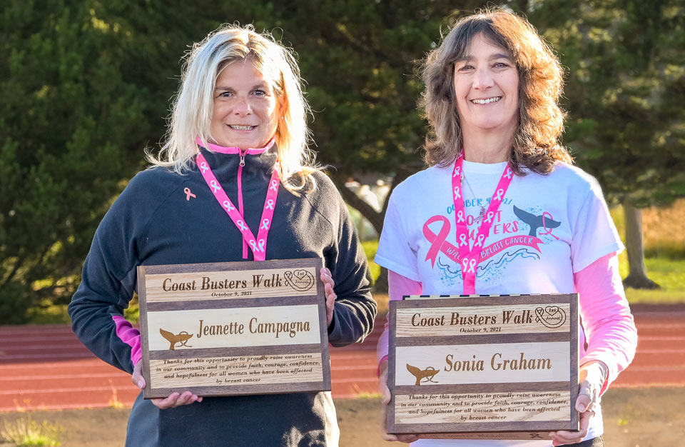 Jeanette and Sonia holding plaques for their annual Coast Busters event in Newport, Oregon.