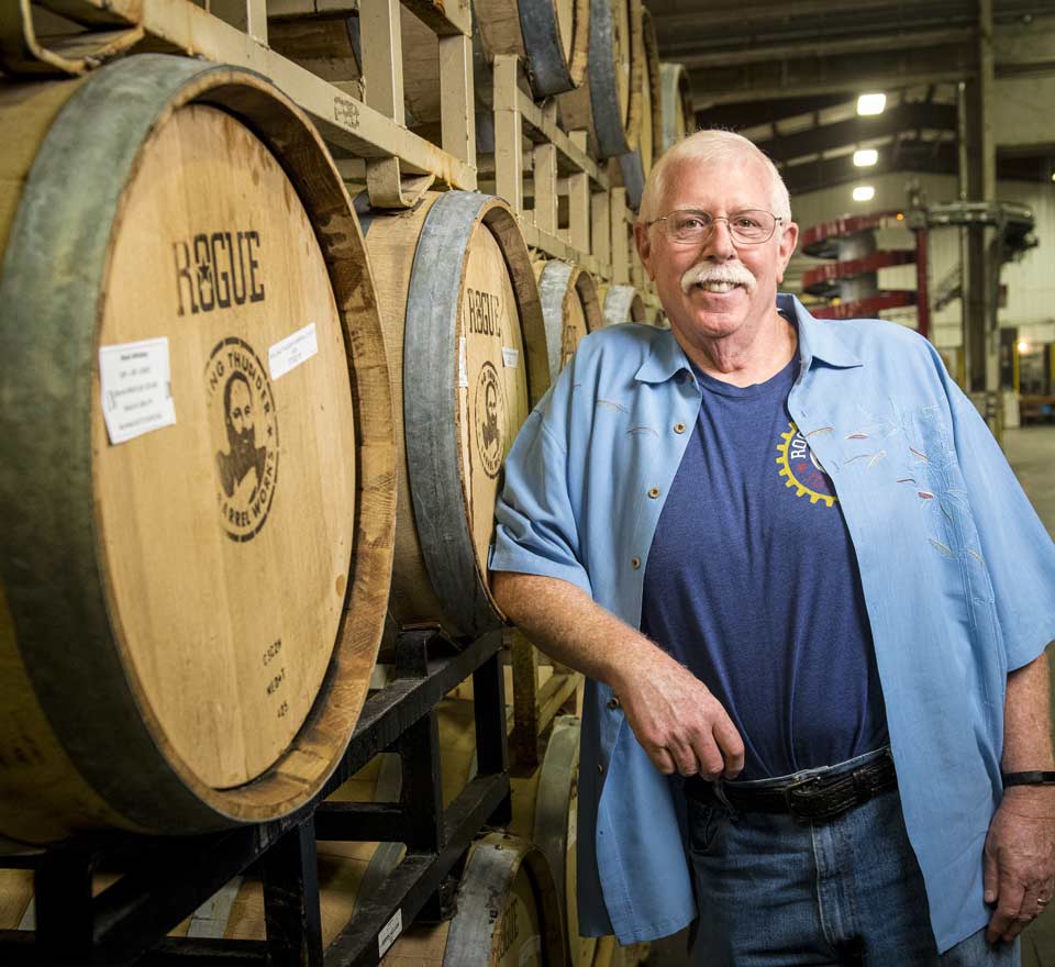 Patient, Jim standing next to kegs, at Rogue Ales brewery in Newport.
