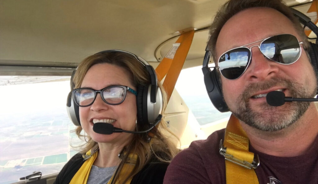 Kent and his wife in the cockpit of his airplane.