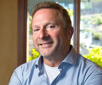Close up of a smiling Kent in his home.