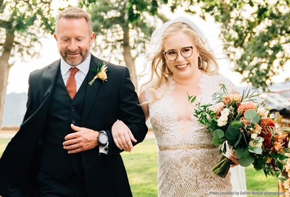 Kent walking his daughter down the aisle at her outdoor wedding.