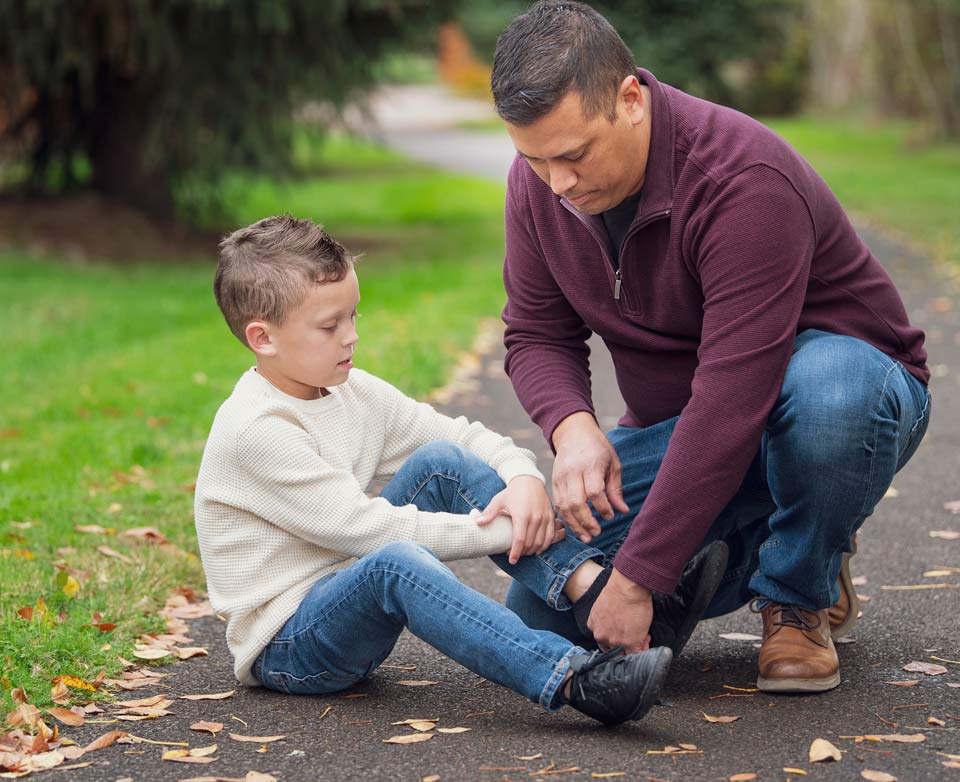 Mike helping his son with his shoe while at a local park.