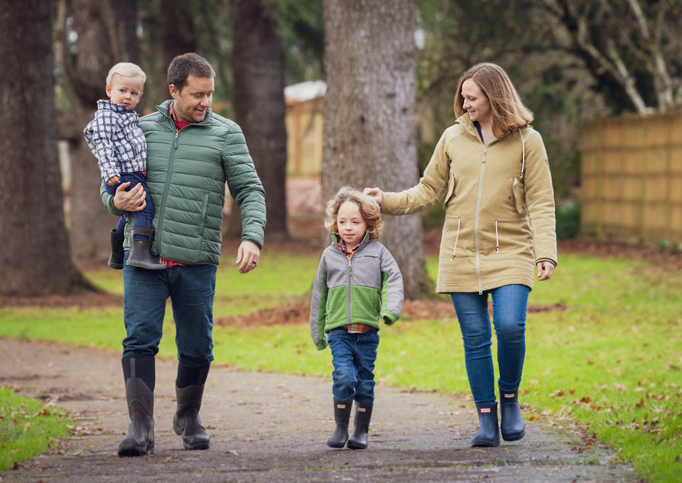 Morgan with her husband and two sons as they walk through a park together.